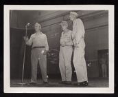 Three men at microphone including Admirals Cassidy, and Halsey 